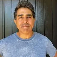 Indian-American comedian, author and director Jay Chandrasekhar with a gray shirt on.